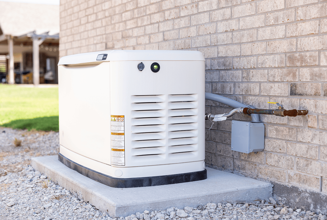 Outdoor home backup generator on concrete pad.